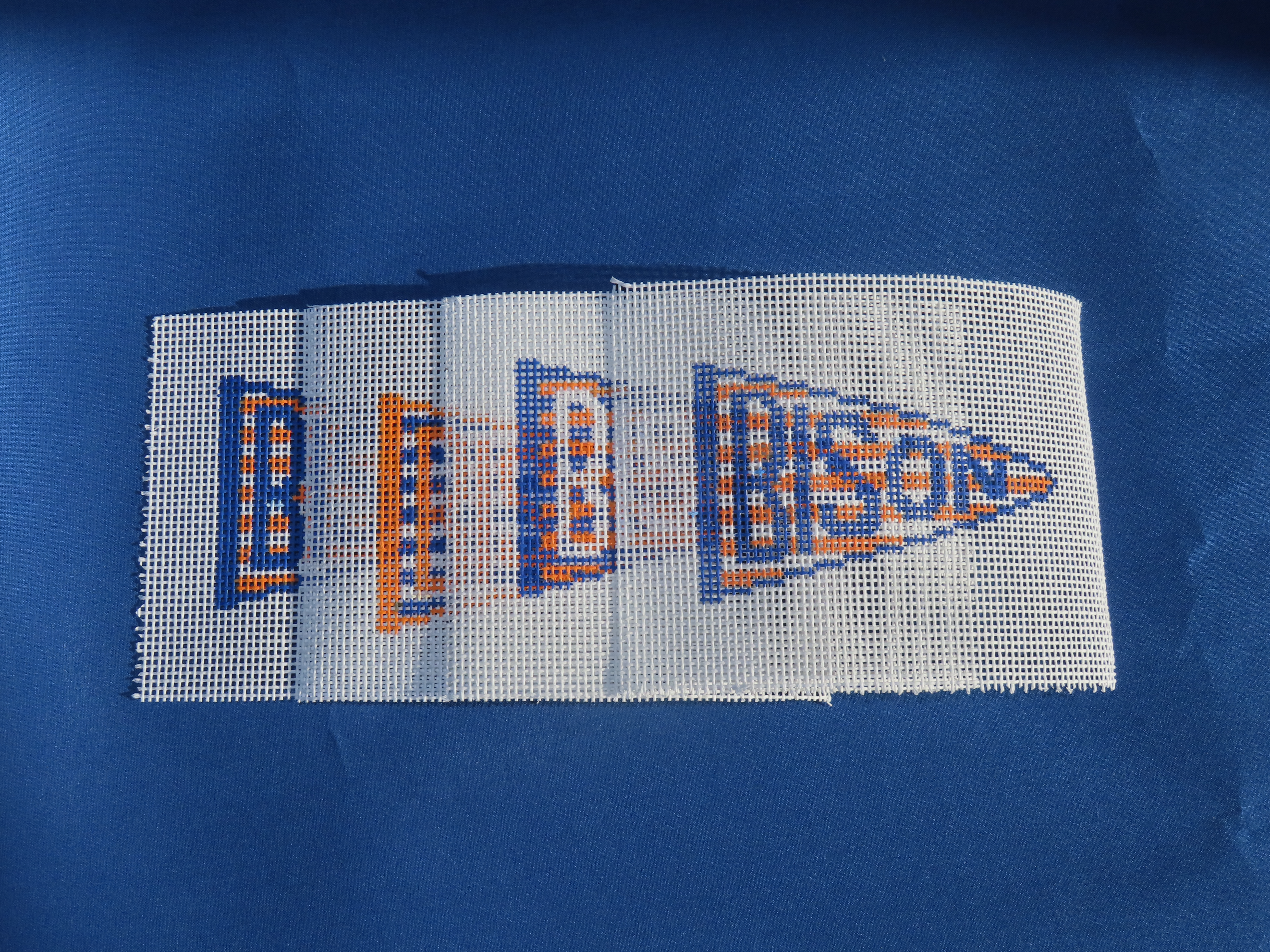 needlepoin canvases stacked horizontally